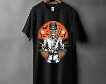 May include: Black t-shirt featuring a baseball-themed graphic. The design shows a skeleton wearing a baseball uniform and holding a bat, set against an orange background with a stadium and bats. The shirt is hanging on a wooden hanger.