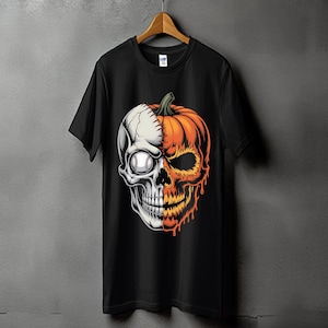 Puede incluir: Camiseta negra con un diseño gráfico de una calavera dividida por la mitad, un lado béisbol, el otro calabaza. El lado del béisbol es blanco, el lado de la calabaza es naranja con un tallo verde. El diseño está centrado en la camiseta.