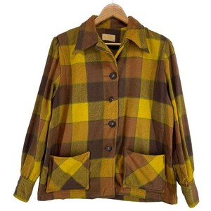 Könnte beinhalten: Vintage karierte Jacke in Gelb-, Braun- und Dunkelbrauntönen. Die Jacke hat einen Kragen, lange Ärmel, zwei Vordertaschen und einen Knopfverschluss. Die Jacke hängt an einem Holzkleiderbügel.