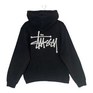 May include: Black hooded sweatshirt with a white logo on the back. The logo is a stylized wordmark. The sweatshirt has a drawstring hood and long sleeves. The garment is hanging on a hanger.