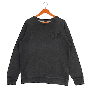 Pode incluir: Camisola cinza escuro com a palavra "DEUS" bordada no peito. A camisa de manga comprida e gola redonda est&aacute; pendurada em um cabide de madeira laranja. A camisola &eacute; feita de um material macio e confort&aacute;vel.