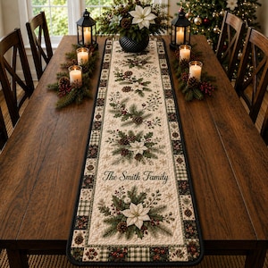 May include: A rectangular quilted table runner featuring a cream-colored center with a repeating pattern of white poinsettias, pine branches, pinecones, and red berries. The text The Smith Family is printed in black script. It has a dark border.