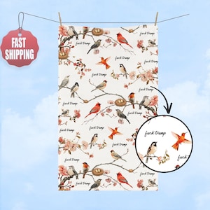 May include: White fabric with a repeating pattern of birds, nests, and floral branches. The words "fuck trump" are interspersed throughout the design. The fabric is hanging from a clothesline against a blue sky.