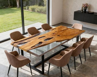 May include: A large, live-edge wooden dining table with a clear epoxy resin fill, supported by a black metal base. Eight upholstered chairs with brown fabric surround the table. The room has large windows and a modern aesthetic.