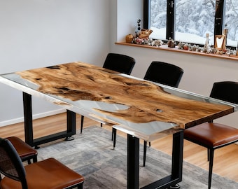 May include: A rectangular wooden dining table with a live edge design, encased in clear resin. The table has black metal legs and is surrounded by black and brown leather chairs. The table measures approximately 72 inches long.