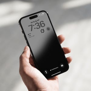 May include: A black smartphone with a lock screen displaying the time 7:36, the date Friday 13, weather information showing 31 degrees, a circular icon with a slash, a G icon, a flashlight icon, a camera icon, and the text 3 Notifications.