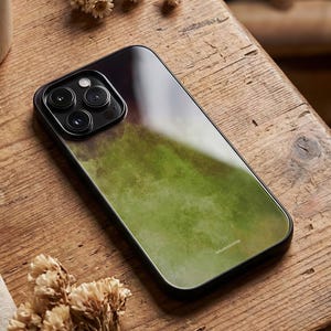 May include: A black smartphone case with a green and brown watercolor design. The case has a glossy finish and a black border. The brand name "liluaetono" is printed on the bottom right corner.