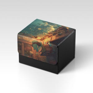 Peut inclure: Une boîte de rangement noire et texturée avec un couvercle à charnière. Le couvercle présente une illustration colorée et détaillée d'une scène de coucher de soleil avec des personnages. La boîte est conçue pour contenir de petits objets.