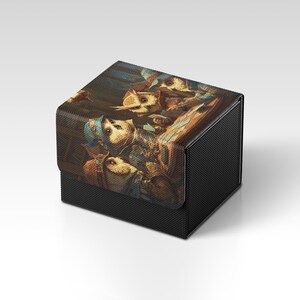 Könnte beinhalten: Eine schwarze, strukturierte Box mit einem Klappdeckel. Der Deckel zeigt eine detaillierte, farbenfrohe Illustration von anthropomorphen Eulen im Vintage-Stil. Das Kunstwerk hat eine warme Farbpalette mit Brauntönen, Blau und Gold.