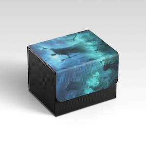 May include: A black box with a textured surface and a hinged lid. The lid features a blue and teal illustration of figures in a cloudy, ethereal scene. The box is designed for storage and organization.