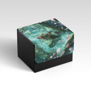 May include: A black storage box with a fabric lid featuring a fantasy illustration. The artwork depicts a figure with a bow and arrow in a serene, aquatic setting with pink blossoms and a teal background.