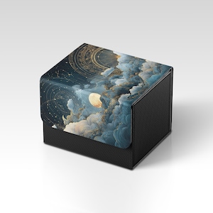 May include: A black, textured box with a celestial design on the lid. The lid features a night sky scene with a moon, clouds, and constellations in shades of blue, gold, and white. The box is square-shaped.