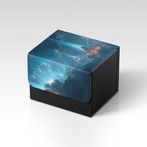 May include: A black box with a textured surface and a lid displaying a blue and orange cloudscape design. The box is square and has a matte finish, ideal for storing small items.