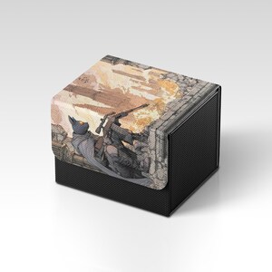 May include: Black card storage box with a detailed illustration of a cat-like figure and a soldier in a war scene. The box has a textured black exterior and a lid with the artwork. The art features muted tones of brown, gray, and yellow.