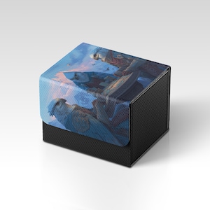 Könnte beinhalten: Eine schwarze, strukturierte Box mit einem Klappdeckel. Der Deckel zeigt eine detaillierte Illustration einer Fantasieszene mit Vögeln und blauem Himmel. Die Box ist wahrscheinlich für die Aufbewahrung kleiner Gegenstände oder Sammlerstücke gedacht.