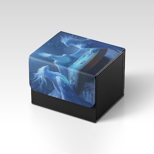 Könnte beinhalten: Eine schwarze und blaue Kartenaufbewahrungsbox. Der Deckel zeigt eine Fantasy-Illustration von ätherischen blauen Figuren. Die Box hat ein strukturiertes Aussehen, das Kohlefaser ähnelt. Die Box dient zur Aufbewahrung von Sammelkarten.