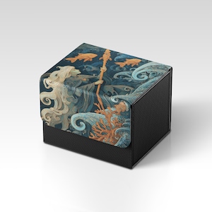 May include: A black box with a detailed illustration of a sea scene. The artwork features a figure with flowing hair, holding a staff, surrounded by fish, coral, and swirling water in shades of blue, orange, and cream.