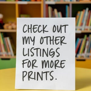 Pu&ograve; includere: Un cartello rettangolare bianco con testo nero scritto a mano che recita: CHECK OUT MY OTHER LISTINGS FOR MORE PRINTS. Il cartello &egrave; posizionato verticalmente su una superficie gialla, liscia e rotonda, con lettere scure e ben leggibili.