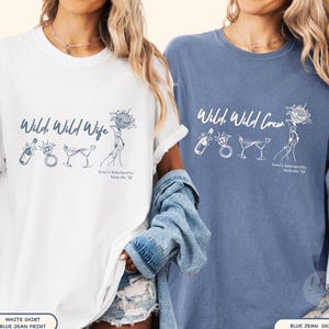 May include: A white t-shirt with blue ink graphics and a blue t-shirt with white ink graphics. Both feature a champagne bottle, diamond ring, two martini glasses, and a disco ball, with the text Wild, Wild Wife or Wild, Wild Crew and Grace's Bachelorette Nashville '26.
