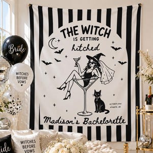 Può includere: Un arazzo da parete bianco e nero con strisce verticali e un'illustrazione centrale di una persona con cappello da strega seduta in un bicchiere da martini con un gatto, testo THE WITCH IS GETTING hitched, Madison's Bachelorette, ottobre 2024.