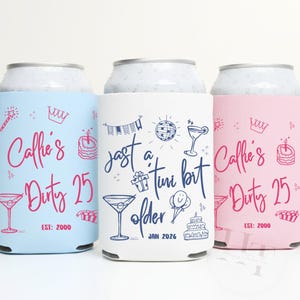 以下が含まれることがあります： ライトブルー、白、ピンクの3つのドリンク缶クーラー。各クーラーには、誕生日をテーマにしたイラストとテキスト（「Callie's Dirty 25」や「Just a tini bit older」など）が描かれています。クーラーは誕生日のパーティー用にデザインされています。