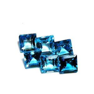 May include: Six square-shaped, faceted, blue topaz gemstones. The gemstones are arranged in a staggered pattern.