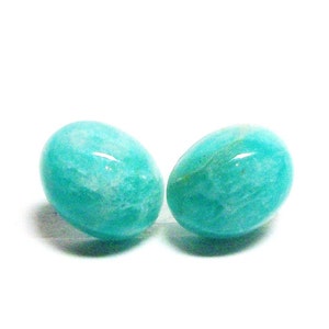 May include: Two oval-shaped teal green gemstones, likely amazonite, with a smooth, polished finish.