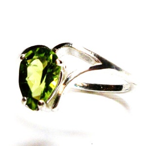 May include: A silver ring with a pear-shaped green gemstone.