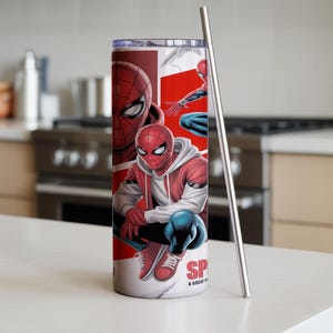 Pu&ograve; includere: Un bicchiere in acciaio inossidabile con un design di Spider-Man. Il bicchiere ha una combinazione di colori rosso, bianco e blu con illustrazioni di Spider-Man in varie pose. Una cannuccia d'argento &egrave; posizionata accanto al bicchiere.