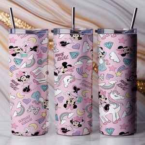 May include: Three pink insulated tumblers with stainless steel straws. The tumblers feature a repeating pattern of Minnie Mouse, unicorns, rainbows, hearts, diamonds, and the text "100% Real" and "Unicorn Dreams".