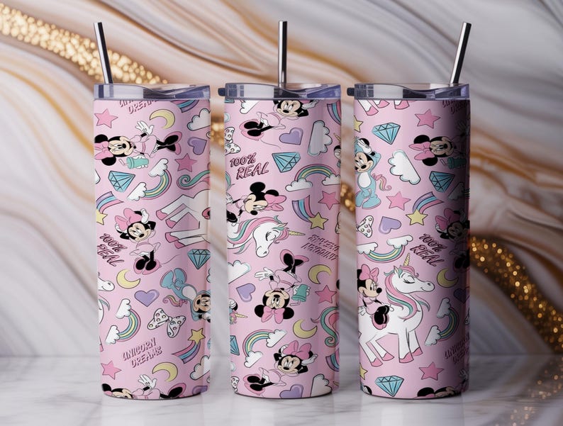 May include: Three pink insulated tumblers with stainless steel straws. The tumblers feature a repeating pattern of Minnie Mouse, unicorns, rainbows, hearts, diamonds, and the text "100% Real" and "Unicorn Dreams".