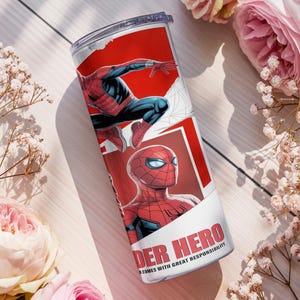 Pu&ograve; includere: Un bicchiere in acciaio inossidabile con illustrazioni di Spider-Man in rosso, nero e blu. Il bicchiere riporta le scritte "SPIDER HERO" e "COMES WITH GREAT RESPONSIBILITY". Il bicchiere &egrave; cilindrico e ha un coperchio trasparente.
