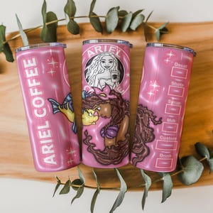 May include: Three pink insulated tumblers with the text "ARIEL COFFEE" and a mermaid graphic. One tumbler features a mermaid with a coffee cup, another has a fish, and the third has drink customization options.