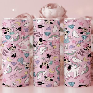 May include: Three pink tumblers with a repeating pattern of Minnie Mouse, unicorns, rainbows, stars, and diamonds. The text "100% REAL" and "UNICORN DREAMS" are also featured on the tumblers. The tumblers are cylindrical and appear to be made of metal.