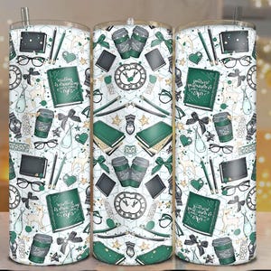 May include: A white tumbler with a repeating pattern of books, coffee cups, eyeglasses, clocks, and pencils in shades of green and black. The tumbler has a straw and the text "reading is dreaming with open eyes."