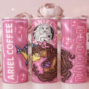 May include: Pink tumbler with "ARIEL COFFEE" text and mermaid-themed graphics. Features a mermaid illustration holding a coffee cup, with drink customization options. The tumbler is approximately 20 cm tall.