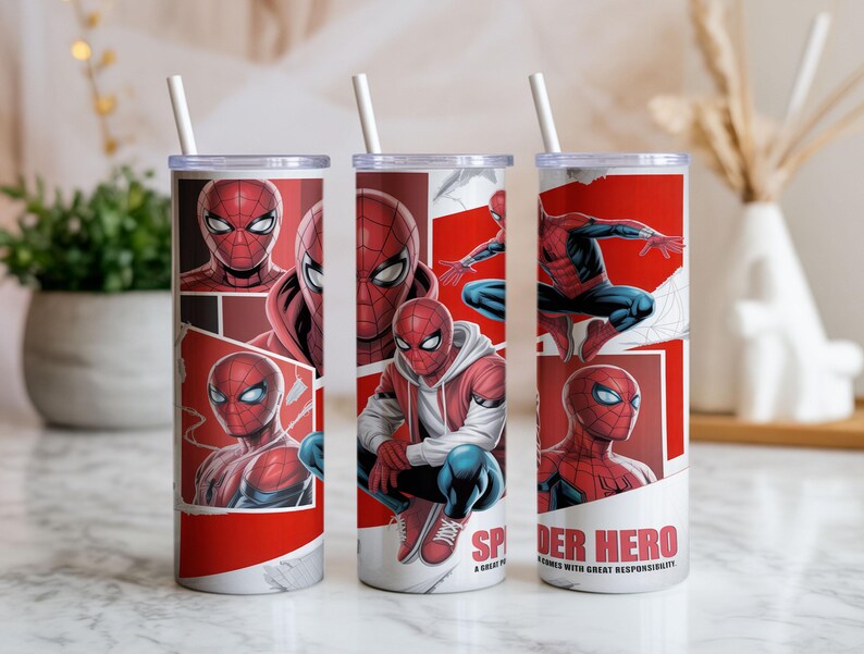 Pu&ograve; includere: Tre bicchieri in acciaio inossidabile con cannucce bianche. Ogni bicchiere presenta un design a fumetti rosso e bianco di Spider-Man. Il testo "SPIDER HERO" &egrave; visibile su un bicchiere.