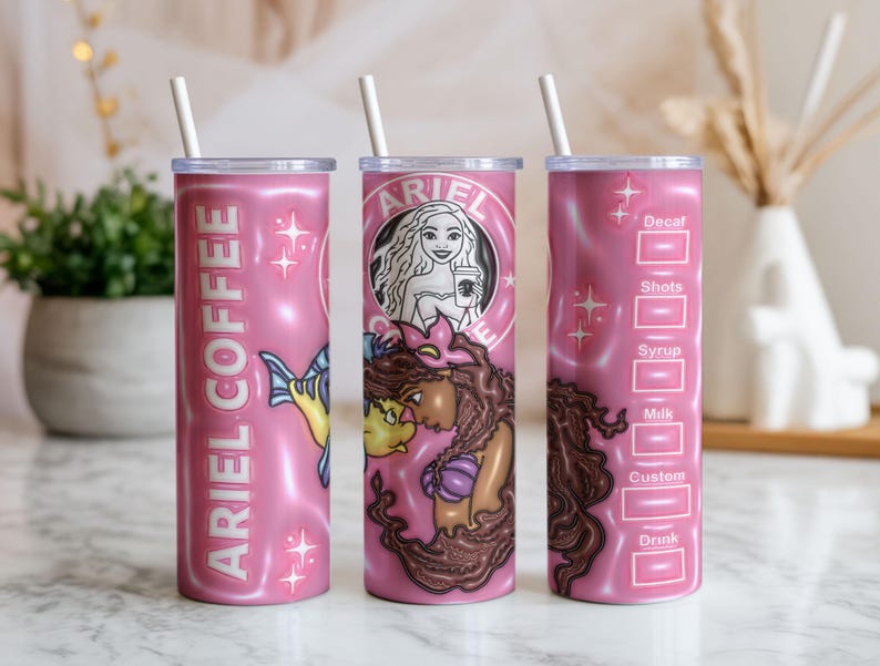 May include: Pink insulated tumbler with a white straw. The tumbler features the text "ARIEL COFFEE" and illustrations of Ariel and Flounder. The design includes a mermaid and coffee cup graphic, with a drink customization chart.