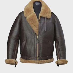 Può includere: Giacca in pelle marrone con colletto e fodera in montone. La giacca presenta una chiusura a zip, una cintura in vita e polsini in montone. La giacca è esposta su un manichino nero.