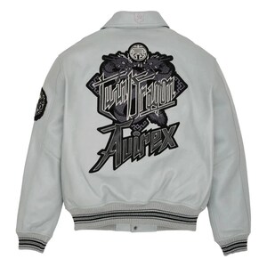 May include: Light gray bomber jacket with a black and gray "Twin Dragon" graphic on the back. The jacket features a collared neckline, ribbed cuffs, and the "Avirex" logo. A small patch is on the left sleeve.