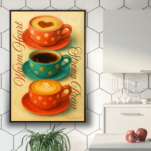 May include: A framed print featuring three coffee cups with different designs. The top cup is orange with white polka dots and a heart design in the foam. The middle cup is turquoise with yellow flower designs. The bottom cup is orange with white polka dots.