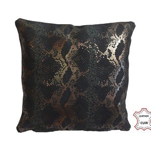 Peut inclure: Coussin carré décoratif avec un motif peau de serpent noir et doré. Le coussin est en cuir et a une surface texturée. Un article de décoration intérieure.