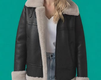 May include: Black leather jacket with a cream-colored shearling collar, cuffs, and interior lining. The jacket features a zip-up front, two side pockets, and a classic aviator style. A stylish outerwear piece.