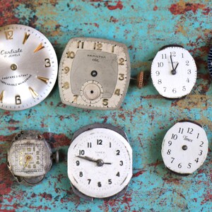May include: A collection of ten vintage wristwatches, featuring a variety of styles and designs. The watches have round, square, and rectangular faces with different coloured dials and hands. Some of the watches have Roman numeral markings, while others have Arabic numeral markings.