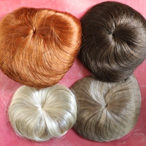 May include: Four hairpieces in different colors: light blonde, brown, dark brown, and red. The hairpieces are round and have a hole in the center.