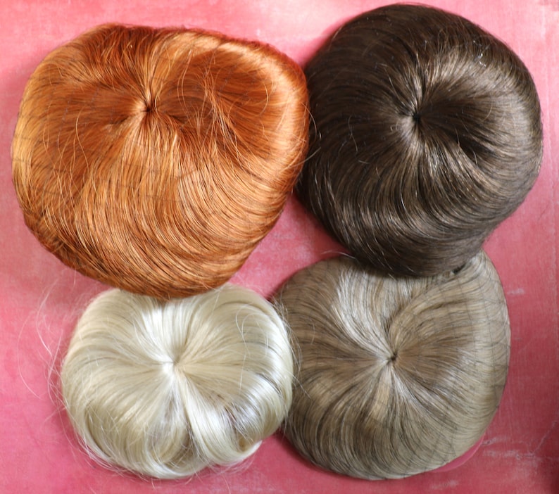 May include: Four hairpieces in different colors: light blonde, brown, dark brown, and red. The hairpieces are round and have a hole in the center.
