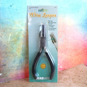 May include: Wire Looper pliers on a teal and white card. The pliers have black handles and a silver head. The card has text that reads "Wire Looper" and "BEADSMITH". The pliers are designed to shape rings and make consistent loops.