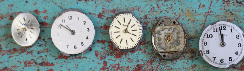 May include: Five vintage watch faces with different styles and designs. The watch faces are all white with black numbers and hands. Some of the watch faces have a gold trim.
