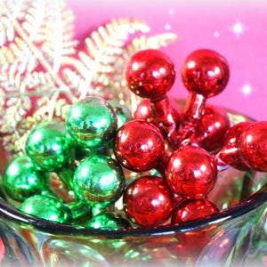 May include: A clear glass vase filled with red and green Christmas ornaments. The ornaments are arranged in a cluster, with the red ornaments on top and the green ornaments on the bottom.
