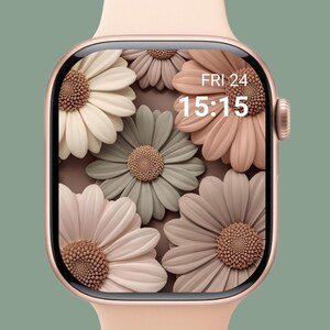 May include: A rose gold smartwatch with a floral display. The watch face features a pattern of large, stylized daisies in shades of white, pink, and green. The date and time, Friday 24, 15:15, are displayed in white text.